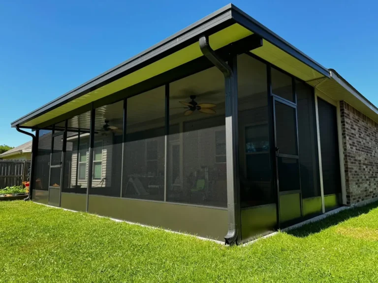 Bronze-frame screen room on a brick home with a manicured green lawn, by Tiger Town Construction