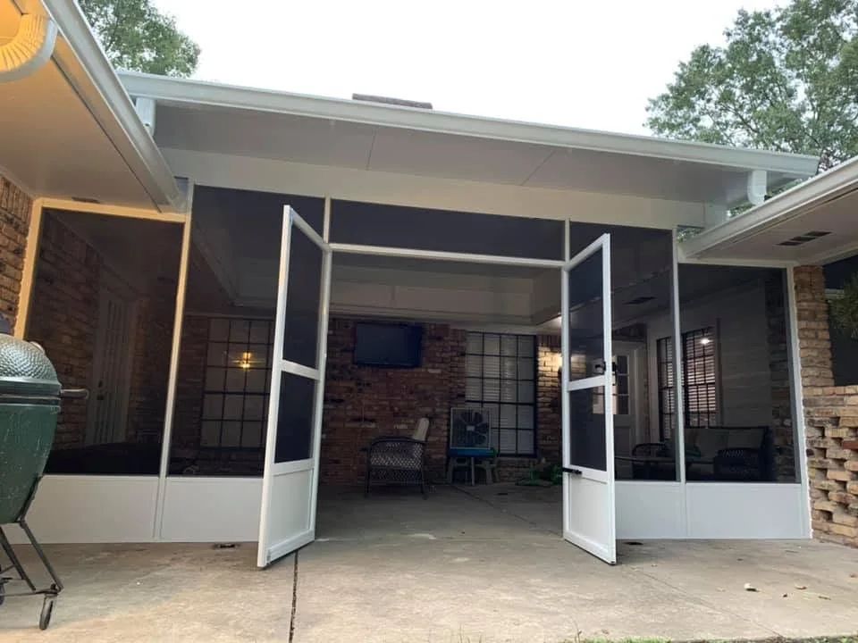 White-frame screen room with open double screen doors and solid lower panels on a brick home, built by Tiger Town Construction