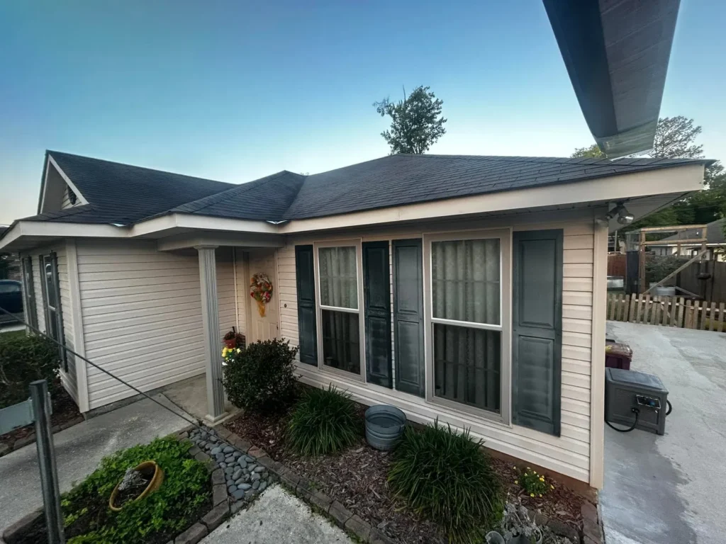Tan-siding home front entry with blue shutters at dusk, by Tiger Town Construction